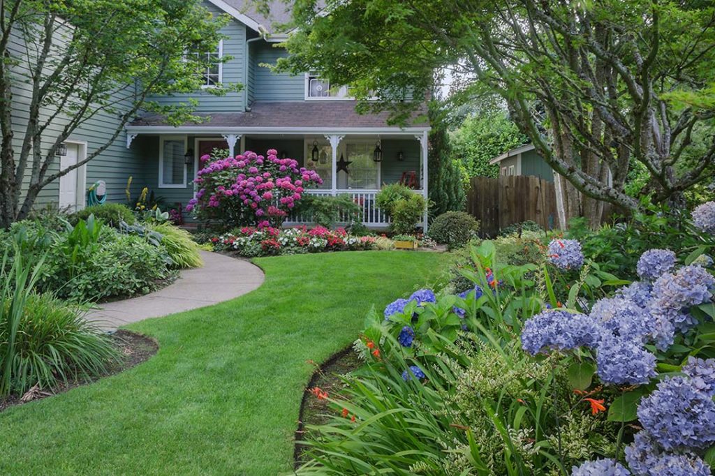 A front yard filled with garden beds and plants that help s to demonstrate the concept of arrangement in garden design
